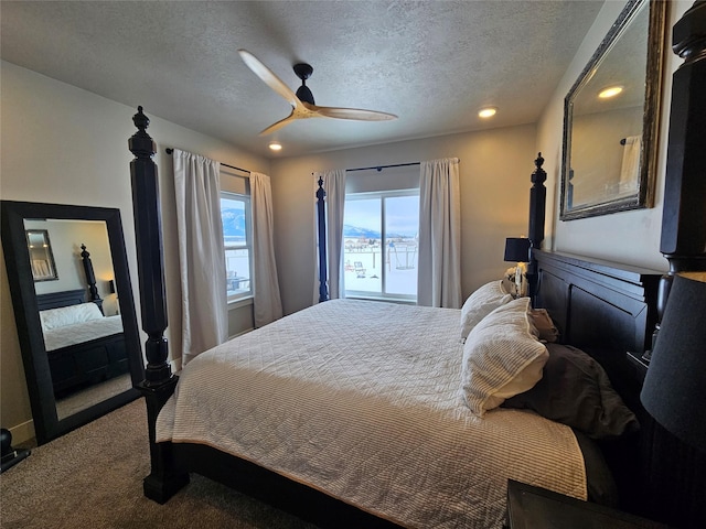 bedroom with a ceiling fan, carpet, and a textured ceiling