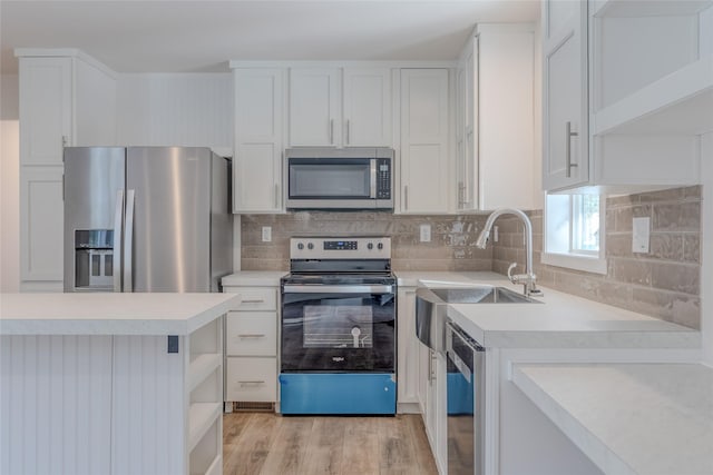 kitchen featuring open shelves, appliances with stainless steel finishes, light countertops, and white cabinetry