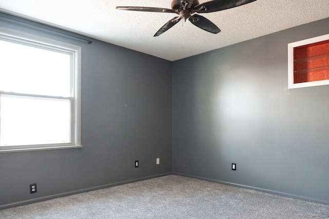 carpeted spare room featuring a ceiling fan, baseboards, and a textured ceiling