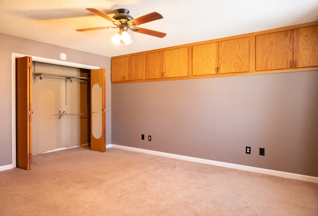 unfurnished bedroom with light carpet, ceiling fan, baseboards, and a closet