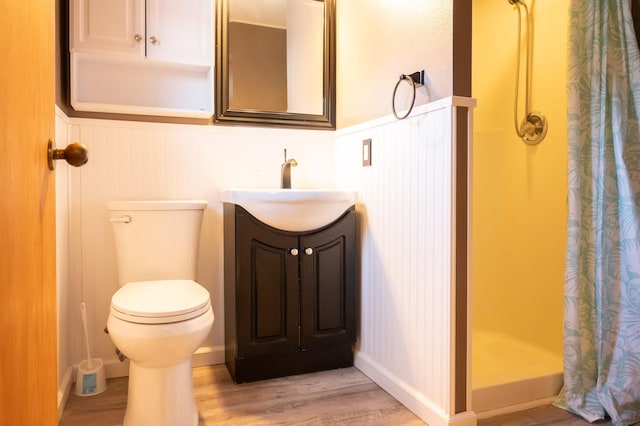 full bath featuring vanity, a stall shower, wood finished floors, and toilet