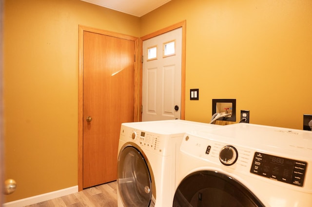 washroom with laundry area, baseboards, light wood finished floors, and separate washer and dryer