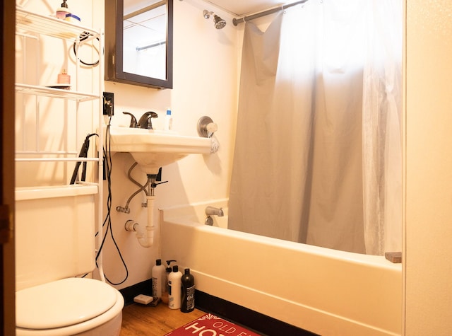 bathroom with toilet, shower / bath combination with curtain, and wood finished floors