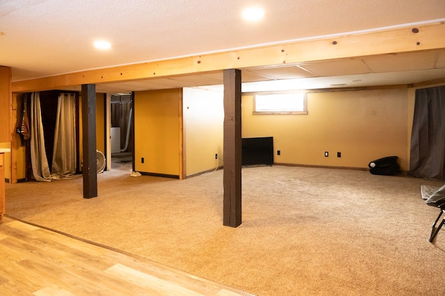 below grade area with carpet floors, baseboards, and wood finished floors