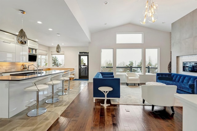 living room with lofted ceiling, a wealth of natural light, wood finished floors, and recessed lighting