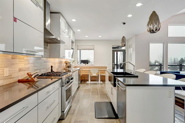 kitchen featuring appliances with stainless steel finishes, dark countertops, white cabinetry, and hanging light fixtures