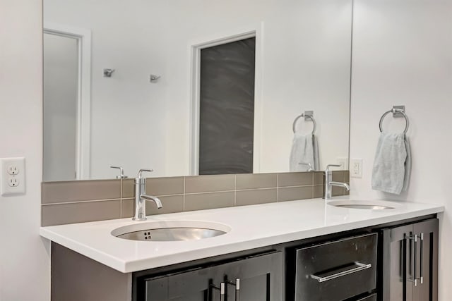 bathroom with double vanity, decorative backsplash, and a sink