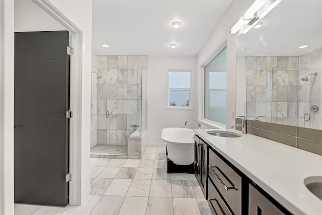 full bath featuring a sink, a freestanding bath, marble finish floor, a shower stall, and double vanity