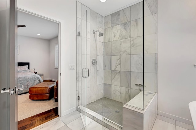 ensuite bathroom with tile patterned floors, ensuite bath, baseboards, and a shower stall