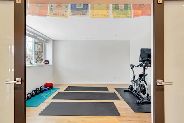 workout room with baseboards and wood finished floors