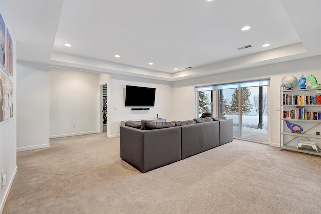 living area featuring a tray ceiling and light colored carpet