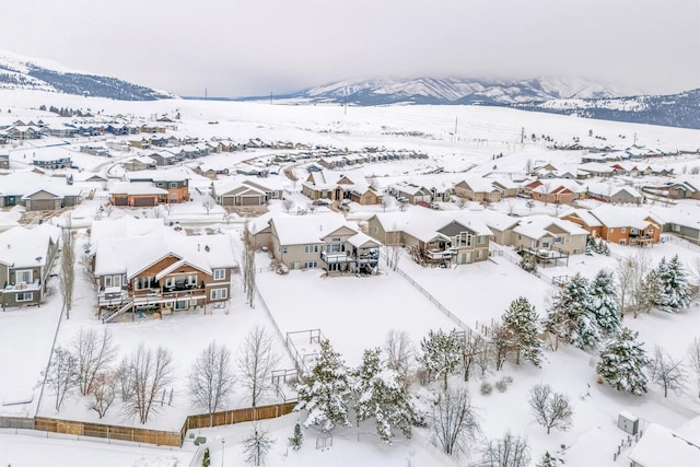 snowy aerial view featuring a residential view and a mountain view