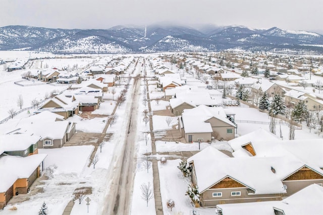 snowy aerial view featuring a residential view and a mountain view