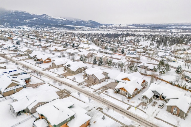 snowy aerial view featuring a residential view and a mountain view