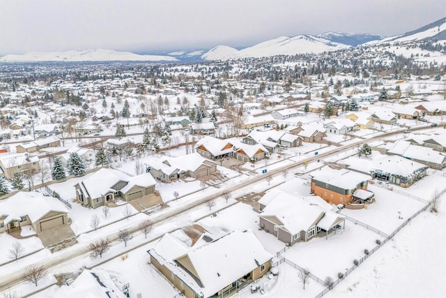 snowy aerial view with a residential view and a mountain view