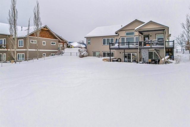 snow covered house with a wooden deck