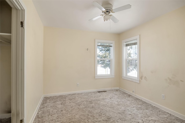 empty room featuring ceiling fan, baseboards, and light colored carpet