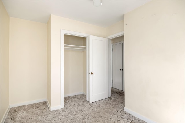 unfurnished bedroom with light carpet, a closet, and baseboards