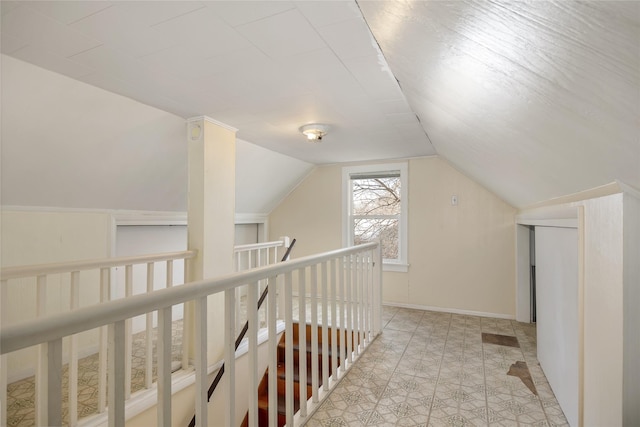 additional living space featuring baseboards and vaulted ceiling