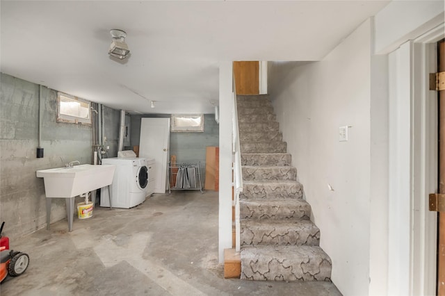 basement with stairway, a sink, and independent washer and dryer