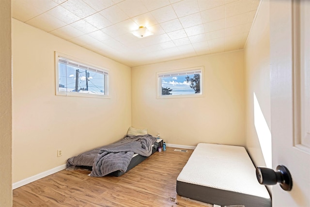 bedroom with visible vents, baseboards, and wood finished floors