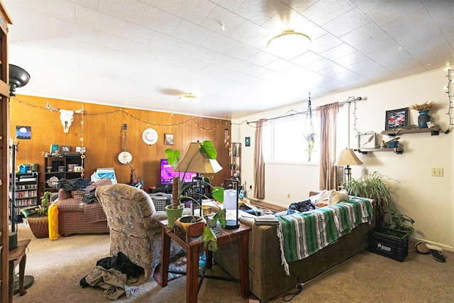 carpeted living area with wood walls