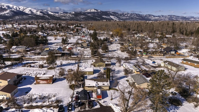 snowy aerial view with a residential view and a mountain view