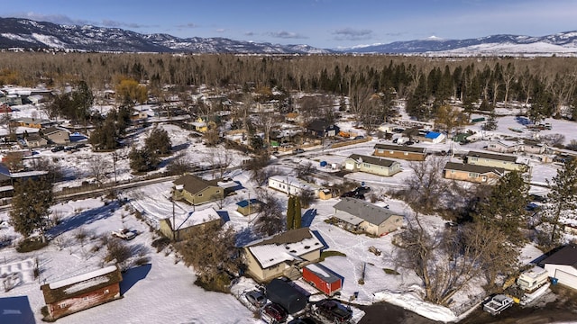 snowy aerial view with a residential view and a mountain view