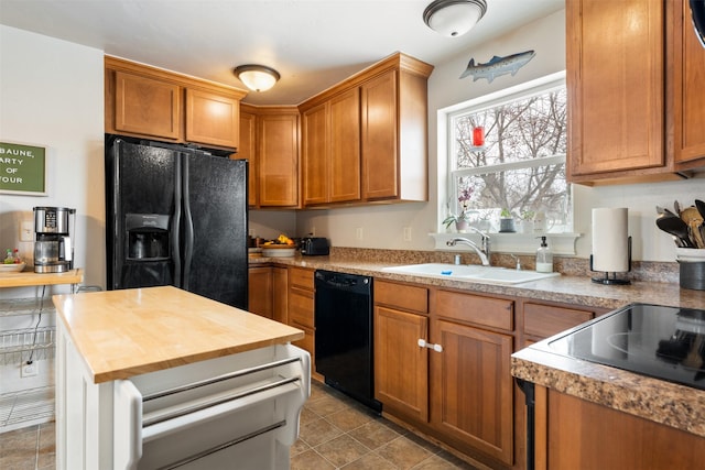 kitchen featuring light tile patterned flooring, butcher block countertops, a sink, brown cabinets, and black appliances