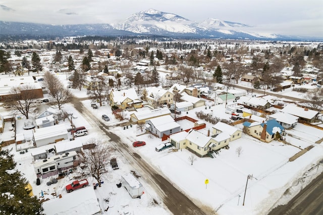 snowy aerial view featuring a residential view and a mountain view