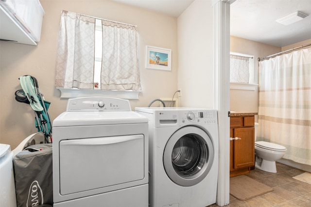 clothes washing area with washer and dryer, laundry area, and visible vents