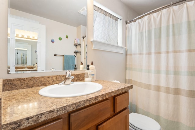 bathroom with toilet, a shower with shower curtain, and vanity