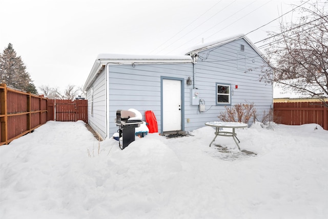 snow covered property featuring a fenced backyard