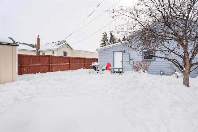 yard covered in snow featuring fence