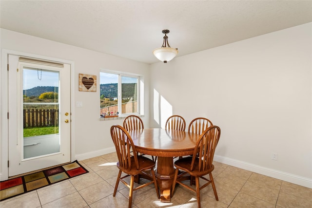 dining area featuring light tile patterned floors and baseboards