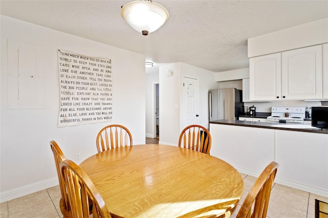 dining area featuring electric panel, a textured ceiling, baseboards, and light tile patterned floors