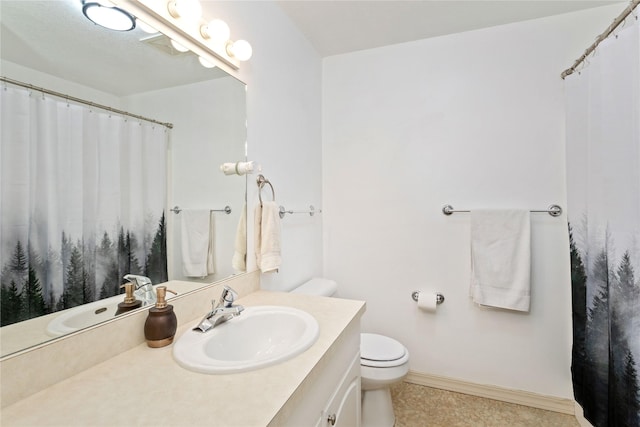 bathroom with toilet, baseboards, and vanity