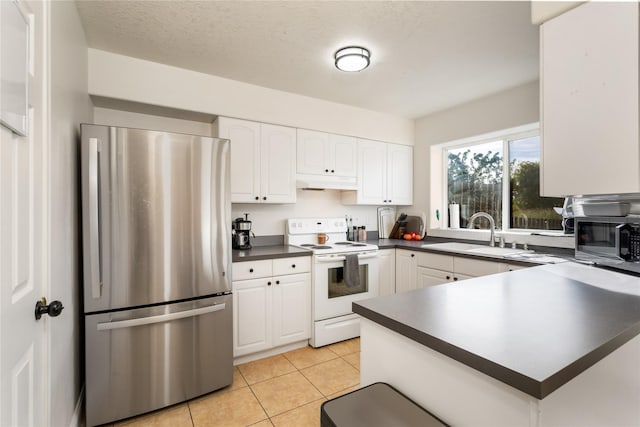 kitchen with stainless steel appliances, dark countertops, white cabinetry, a sink, and under cabinet range hood