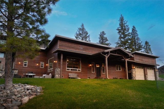 view of front facade with stone siding and a front lawn