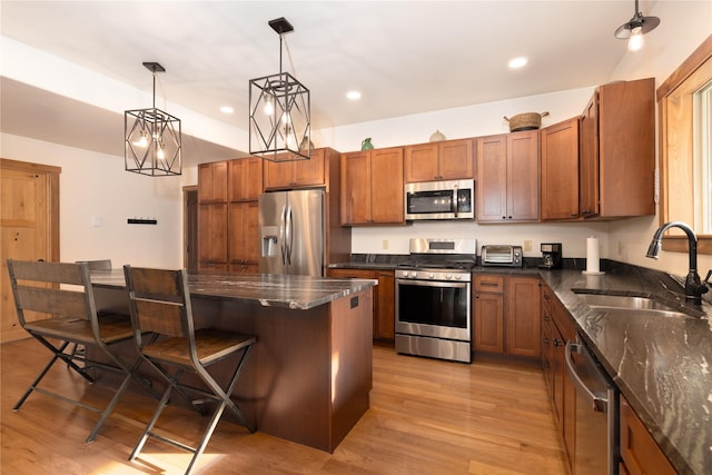 56 Nelson Dr, Rexford, MT 59930 - kitchen featuring a breakfast bar, a sink, hanging light fixtures, appliances with stainless steel finishes, and a center island