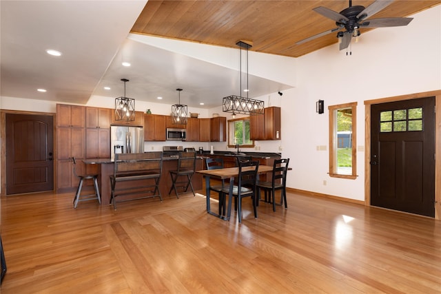 56 Nelson Dr, Rexford, MT 59930 - kitchen with a breakfast bar area, hanging light fixtures, appliances with stainless steel finishes, light wood-type flooring, and a center island