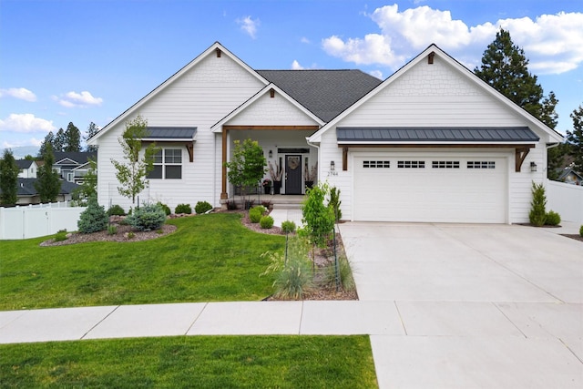 view of front of home with concrete driveway, a front yard, a standing seam roof, fence, and a garage