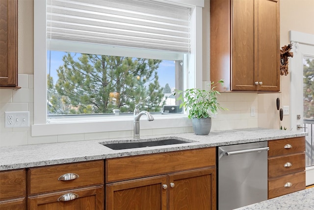 kitchen with a healthy amount of sunlight, a sink, and light stone countertops