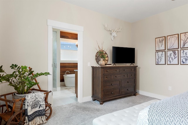 bedroom with light carpet, connected bathroom, and baseboards