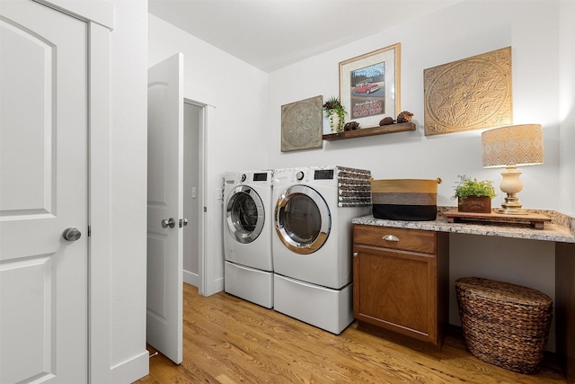 clothes washing area with light wood finished floors, laundry area, and independent washer and dryer