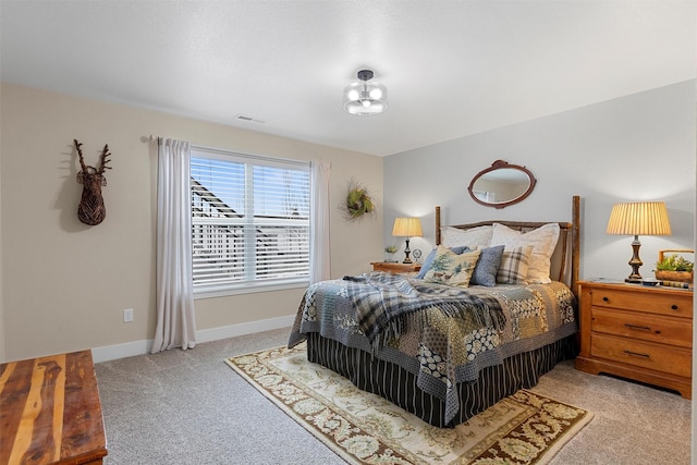 bedroom with visible vents, light carpet, and baseboards