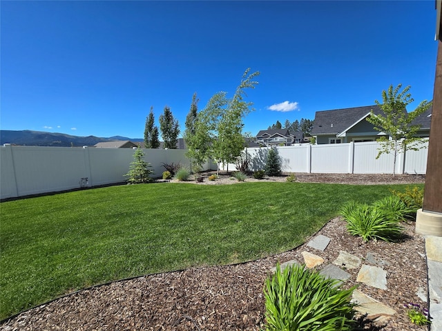 view of yard featuring a fenced backyard and a mountain view