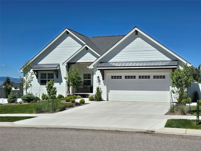 view of front of home featuring concrete driveway, metal roof, an attached garage, and a standing seam roof