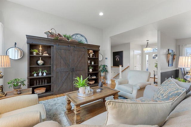 living room with baseboards, a barn door, wood finished floors, and recessed lighting