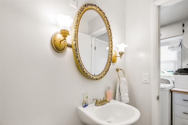 bathroom with washer / clothes dryer and a sink